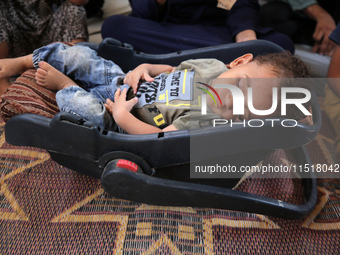 Palestinian infant Abdul Rahman Abu Al-Jidyan, 11, who contracts polio, receives care from his mother and family inside a tent in a shelter...