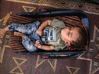 Palestinian infant Abdul Rahman Abu Al-Jidyan, 11, who contracts polio, receives care from his mother and family inside a tent in a shelter...