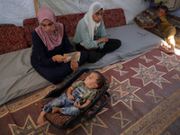 Palestinian infant Abdul Rahman Abu Al-Jidyan, 11, who contracts polio, receives care from his mother and family inside a tent in a shelter...