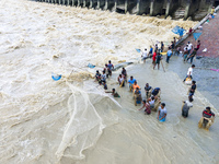 Fishermen and common people fish with handmade nets on the banks of the Feni River, ignoring the strong flow of floodwater along the Muhuri...