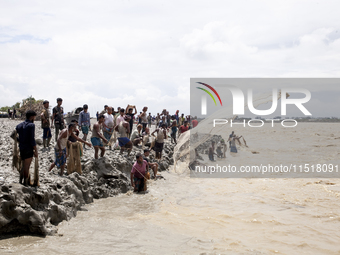 Fishermen and common people fish with handmade nets on the banks of the Feni River, ignoring the strong flow of floodwater along the Muhuri...