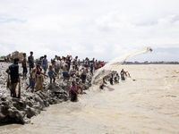 Fishermen and common people fish with handmade nets on the banks of the Feni River, ignoring the strong flow of floodwater along the Muhuri...