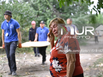 An elderly woman wipes away tears during a response effort to a Russian Shahed drone collapse in a residential area in Zaporizhzhia, Ukraine...