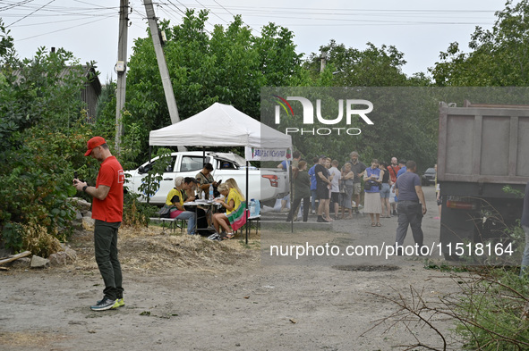 Locals accept aid after a Russian Shahed drone falls onto a residential area in Zaporizhzhia, Ukraine, on August 27, 2024. NO USE RUSSIA. NO...