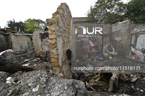 Women search the ruins of a house for surviving items after a Russian Shahed drone falls onto a residential area in Zaporizhzhia, Ukraine, o...