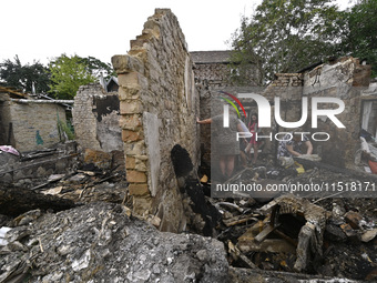 Women search the ruins of a house for surviving items after a Russian Shahed drone falls onto a residential area in Zaporizhzhia, Ukraine, o...