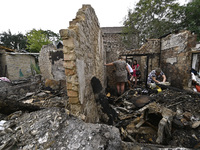 Women search the ruins of a house for surviving items after a Russian Shahed drone falls onto a residential area in Zaporizhzhia, Ukraine, o...