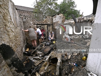 Women search the ruins of a house for surviving items after a Russian Shahed drone falls onto a residential area in Zaporizhzhia, Ukraine, o...