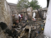 Women search the ruins of a house for surviving items after a Russian Shahed drone falls onto a residential area in Zaporizhzhia, Ukraine, o...