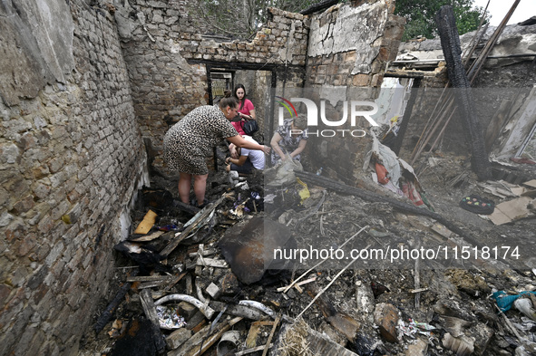 Women search the ruins of a house for surviving items after a Russian Shahed drone falls onto a residential area in Zaporizhzhia, Ukraine, o...