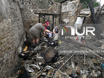 Women search the ruins of a house for surviving items after a Russian Shahed drone falls onto a residential area in Zaporizhzhia, Ukraine, o...