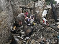 Women search the ruins of a house for surviving items after a Russian Shahed drone falls onto a residential area in Zaporizhzhia, Ukraine, o...