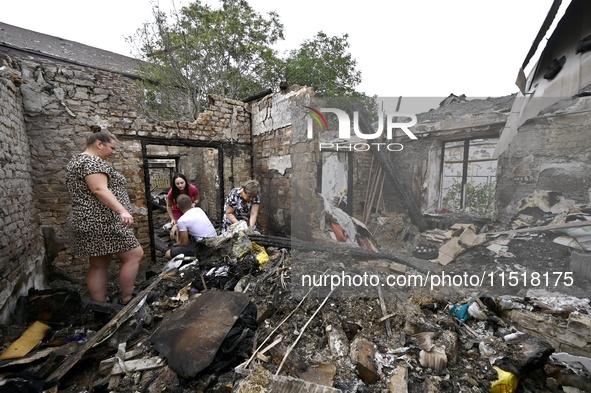 Women search the ruins of a house for surviving items after a Russian Shahed drone falls onto a residential area in Zaporizhzhia, Ukraine, o...