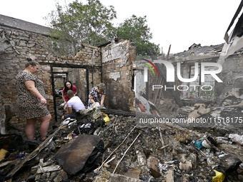 Women search the ruins of a house for surviving items after a Russian Shahed drone falls onto a residential area in Zaporizhzhia, Ukraine, o...