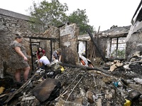 Women search the ruins of a house for surviving items after a Russian Shahed drone falls onto a residential area in Zaporizhzhia, Ukraine, o...