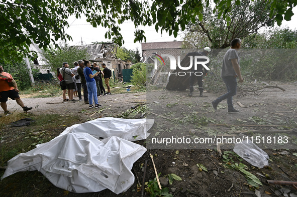 The bodies of victims in human remains pouches are on the ground during a response effort to a Russian Shahed drone collapse in a residentia...