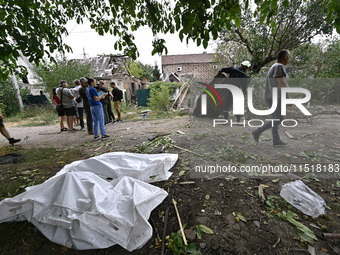 The bodies of victims in human remains pouches are on the ground during a response effort to a Russian Shahed drone collapse in a residentia...