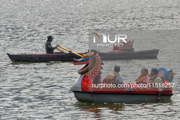 Indian tourists paddle boat along Naini Lake in Nainital, Uttarakhand, India, on April 21, 2024. 