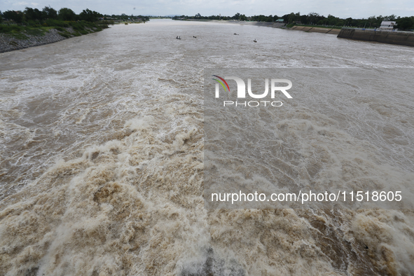 Villagers fish on their boat near the Chao Phraya Dam in Chai Nat province, north of Bangkok, on August 27, 2024. The dam releases water due...