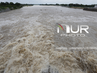 Villagers fish on their boat near the Chao Phraya Dam in Chai Nat province, north of Bangkok, on August 27, 2024. The dam releases water due...