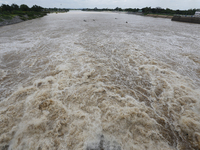 Villagers fish on their boat near the Chao Phraya Dam in Chai Nat province, north of Bangkok, on August 27, 2024. The dam releases water due...