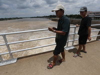 People watch as floodwaters are released from the Chao Phraya Dam in Chai Nat province, north of Bangkok, on August 27, 2024. The dam releas...