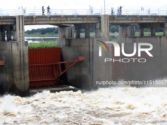 People watch as floodwaters are released from the Chao Phraya Dam in Chai Nat province, north of Bangkok, on August 27, 2024. The dam releas...