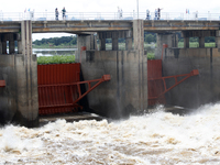 People watch as floodwaters are released from the Chao Phraya Dam in Chai Nat province, north of Bangkok, on August 27, 2024. The dam releas...