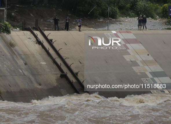 Villagers fish near the Chao Phraya Dam in Chai Nat province, north of Bangkok, on August 27, 2024. The dam releases water due to heavy floo...