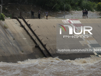 Villagers fish near the Chao Phraya Dam in Chai Nat province, north of Bangkok, on August 27, 2024. The dam releases water due to heavy floo...