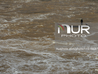 Villagers fish on their boat near the Chao Phraya Dam in Chai Nat province, north of Bangkok, on August 27, 2024. The dam releases water due...