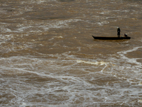 Villagers fish on their boat near the Chao Phraya Dam in Chai Nat province, north of Bangkok, on August 27, 2024. The dam releases water due...