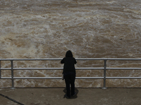 People watch as floodwaters are released from the Chao Phraya Dam in Chai Nat province, north of Bangkok, on August 27, 2024. The dam releas...