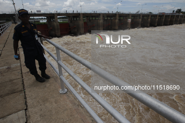 People watch as floodwaters are released from the Chao Phraya Dam in Chai Nat province, north of Bangkok, on August 27, 2024. The dam releas...