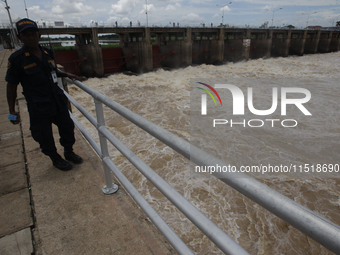 People watch as floodwaters are released from the Chao Phraya Dam in Chai Nat province, north of Bangkok, on August 27, 2024. The dam releas...