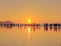 Tourists watch the sunrise at the Golden Beach in Qingdao, China, on August 28, 2024. (