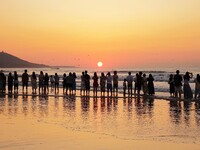 Tourists watch the sunrise at the Golden Beach in Qingdao, China, on August 28, 2024. (