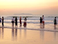 Tourists watch the sunrise at the Golden Beach in Qingdao, China, on August 28, 2024. (