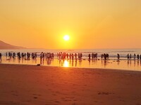 Tourists watch the sunrise at the Golden Beach in Qingdao, China, on August 28, 2024. (