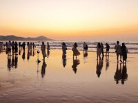 Tourists watch the sunrise at the Golden Beach in Qingdao, China, on August 28, 2024. (