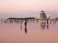 Tourists watch the sunrise at the Golden Beach in Qingdao, China, on August 28, 2024. (