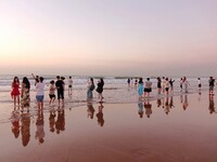 Tourists watch the sunrise at the Golden Beach in Qingdao, China, on August 28, 2024. (