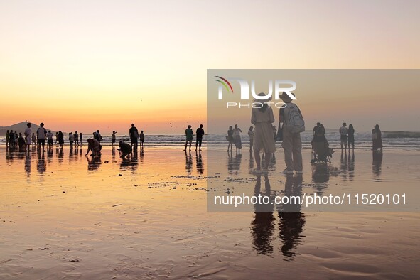 Tourists watch the sunrise at the Golden Beach in Qingdao, China, on August 28, 2024. 