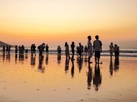 Tourists watch the sunrise at the Golden Beach in Qingdao, China, on August 28, 2024. (