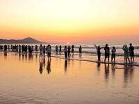 Tourists watch the sunrise at the Golden Beach in Qingdao, China, on August 28, 2024. (