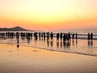 Tourists watch the sunrise at the Golden Beach in Qingdao, China, on August 28, 2024. (