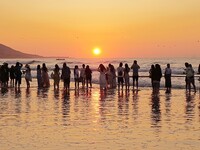 Tourists watch the sunrise at the Golden Beach in Qingdao, China, on August 28, 2024. (