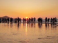 Tourists watch the sunrise at the Golden Beach in Qingdao, China, on August 28, 2024. (