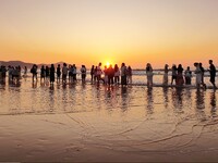 Tourists watch the sunrise at the Golden Beach in Qingdao, China, on August 28, 2024. (