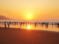 Tourists watch the sunrise at the Golden Beach in Qingdao, China, on August 28, 2024. (